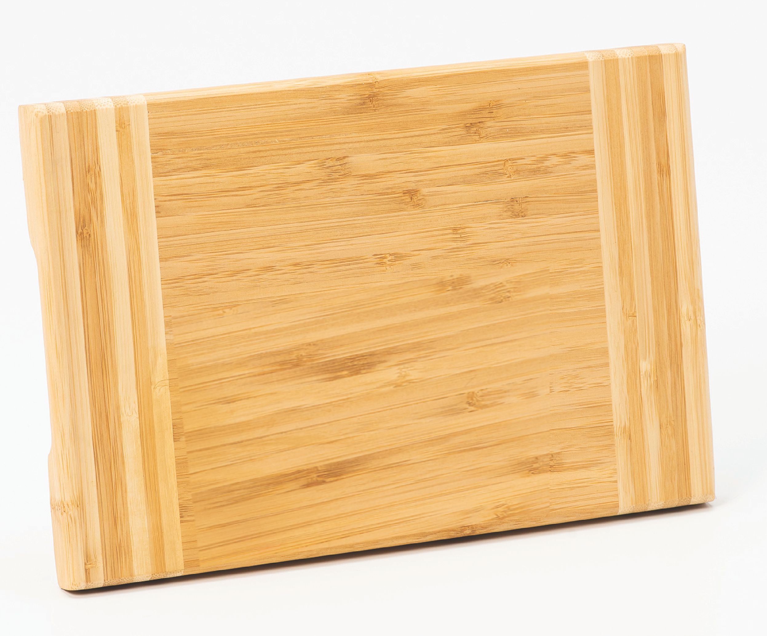The Prize Possessions Bamboo Cutting Board, featuring light and dark wood grain patterns with two lighter stripes at each end and a knife-friendly surface, stands upright against a white background.