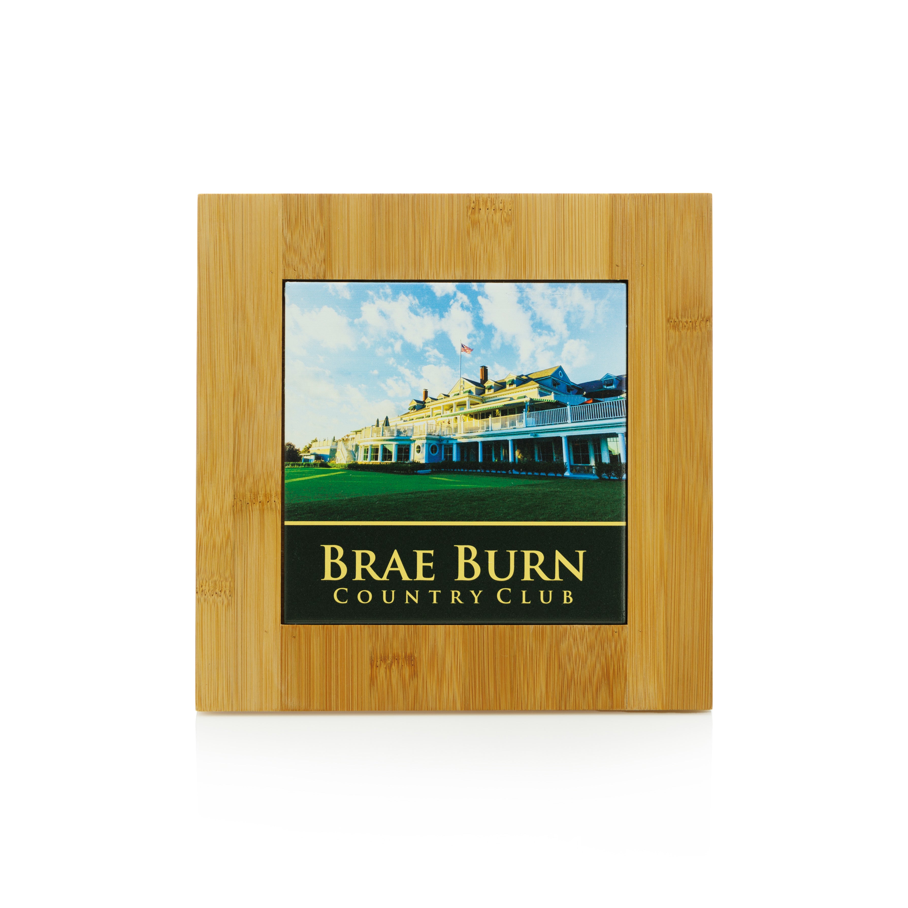 The Prize Possessions Bamboo Trivet with Tile stylishly displays a photo of Brae Burn Country Club and doubles as a heat-resistant kitchen trivet, perfect for modern decor.