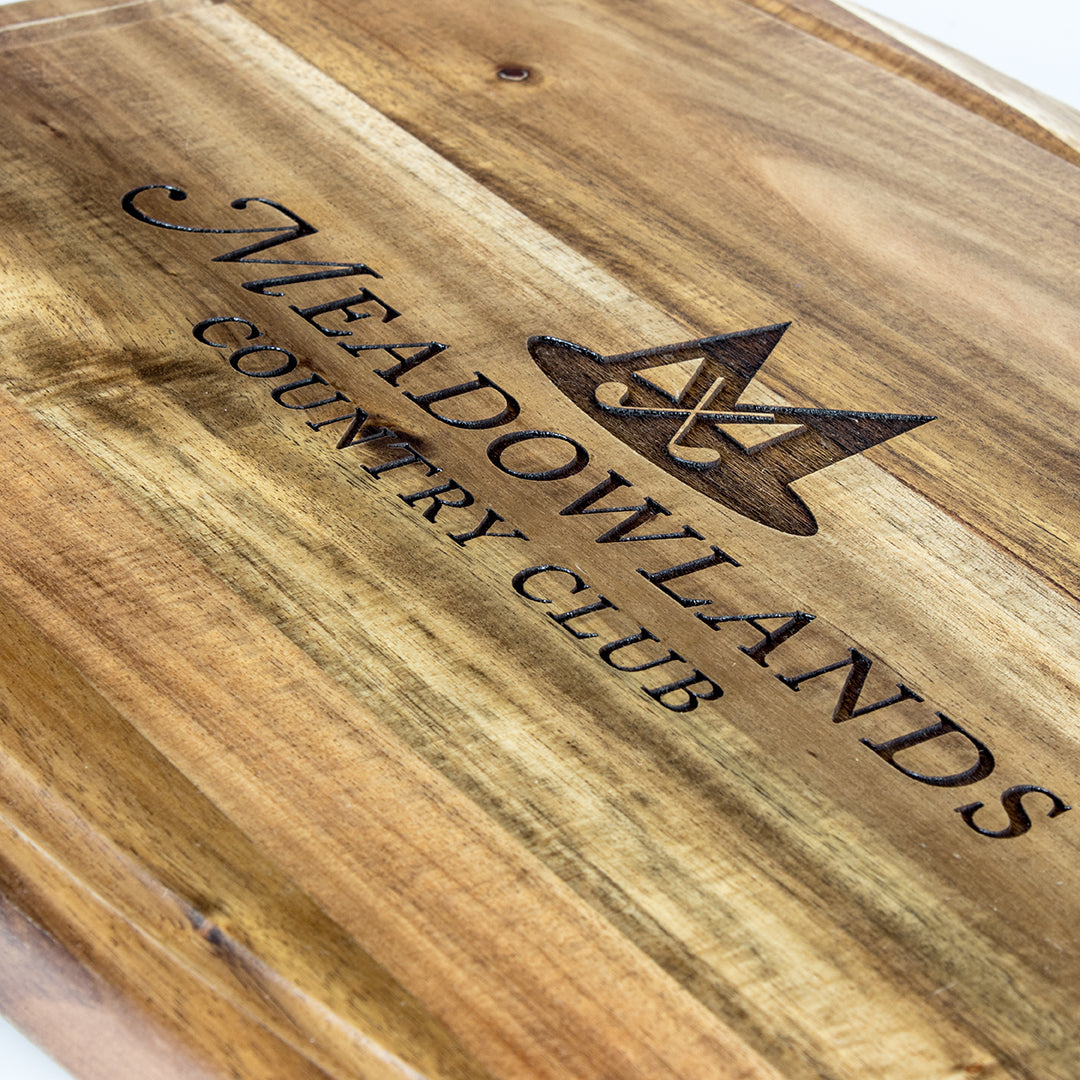 The Prize Possessions Barrel Shape Cutting Board is engraved with "Meadowlands Country Club" and a stylized "M" logo above the text.