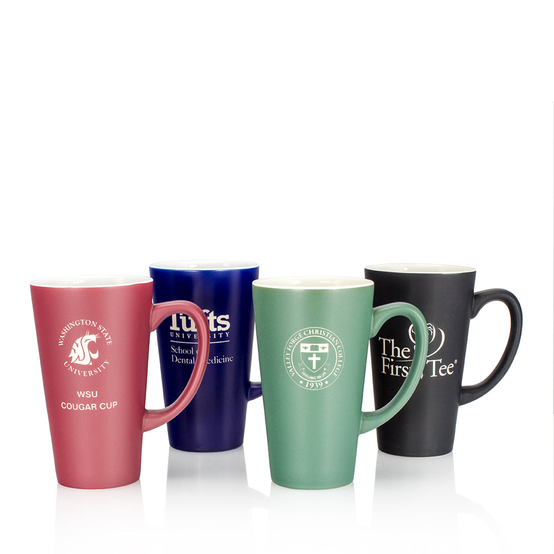 Four "Blue with White Inside Ceramic Mug" by Prize Possessions and three other colored ceramic mugs, each featuring a unique university or organization logo and text, are arranged side by side on a white background.