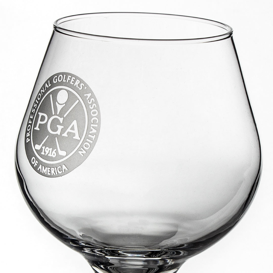 The Prize Possessions Brandy Snifter is clear crystal glassware etched with the Professional Golfers Association of America (PGA) logo and "1916" in white on the side.