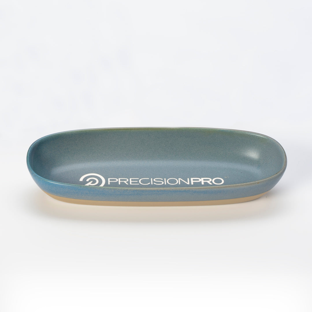 The Prize Possessions Ceramic Nevada Gray/Sand Strata Platter features a shallow, oval shape with a matte gray interior and sand exterior, logo printed in white. Ideal for modern tablescapes, shown on a plain white background.