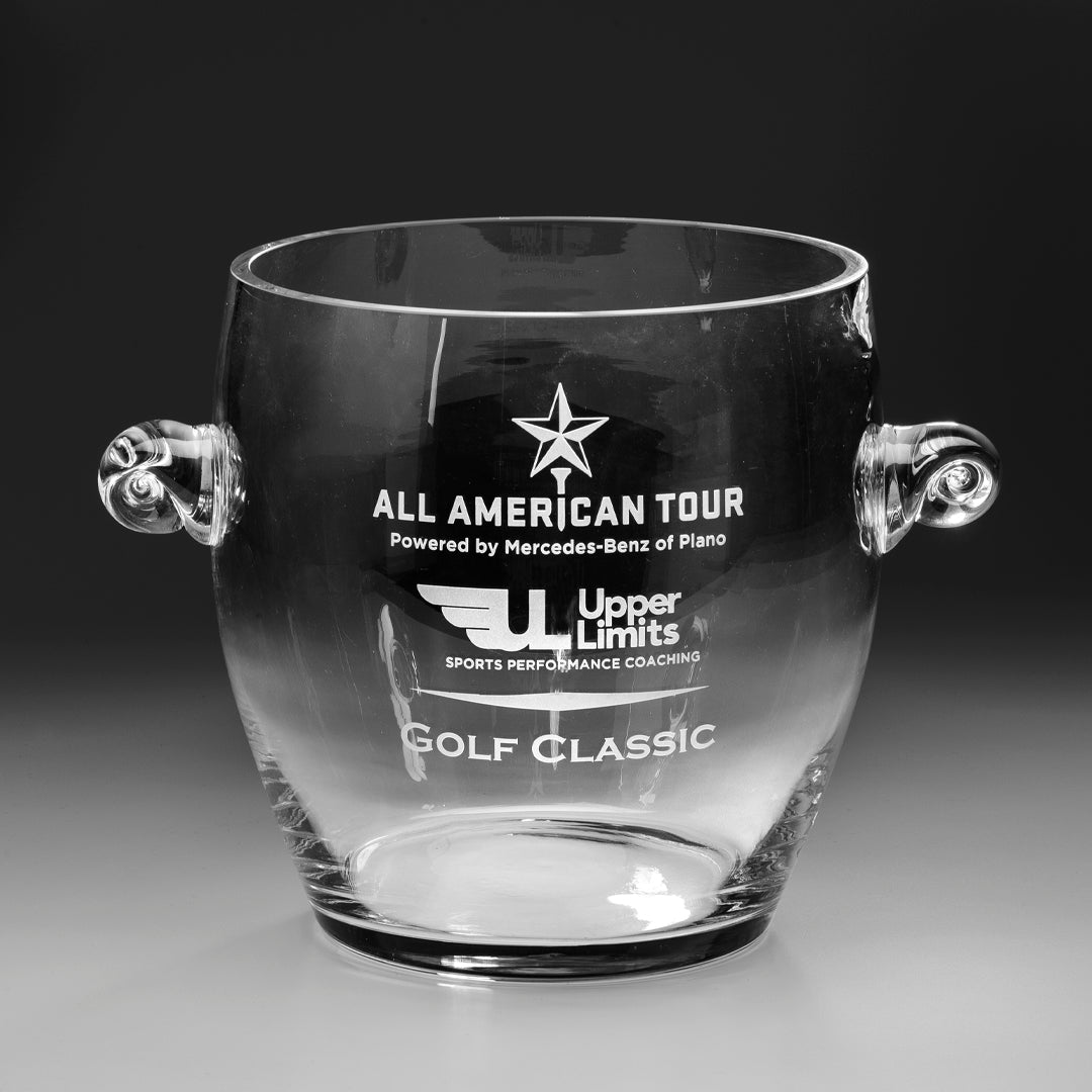 The Prize Possessions Crystal Ice Bucket features elegant side handles and is engraved with ALL AMERICAN TOUR Powered by Mercedes-Benz of Plano, the Upper Limits logo, and GOLF CLASSIC—a stunning home entertaining accessory set against a gray background.