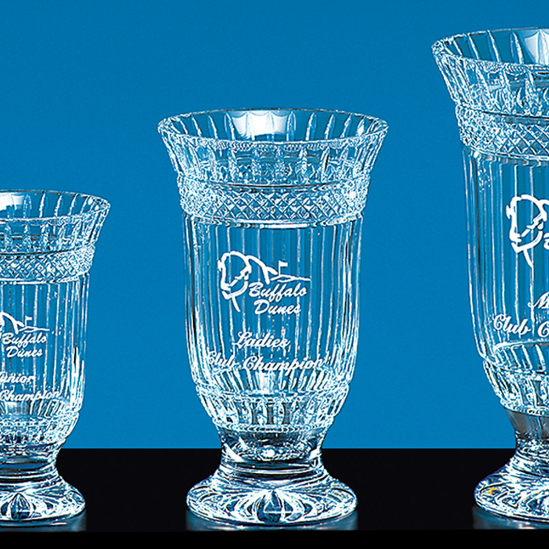 Three Prize Possessions Crystal Kilmore Awards, featuring ornate engraving and intricate designs, are displayed on a black surface against a blue background—ideal for corporate recognition.