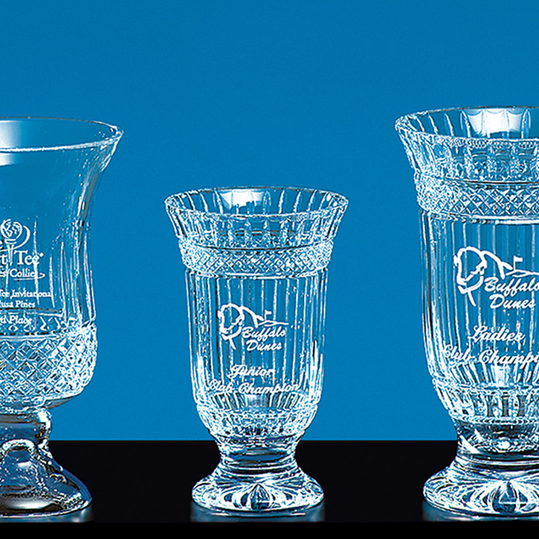 Three Crystal Kilmore Awards by Prize Possessions in various heights are shown against a bright blue background, each featuring engraved text and logos to honor outstanding corporate achievement.