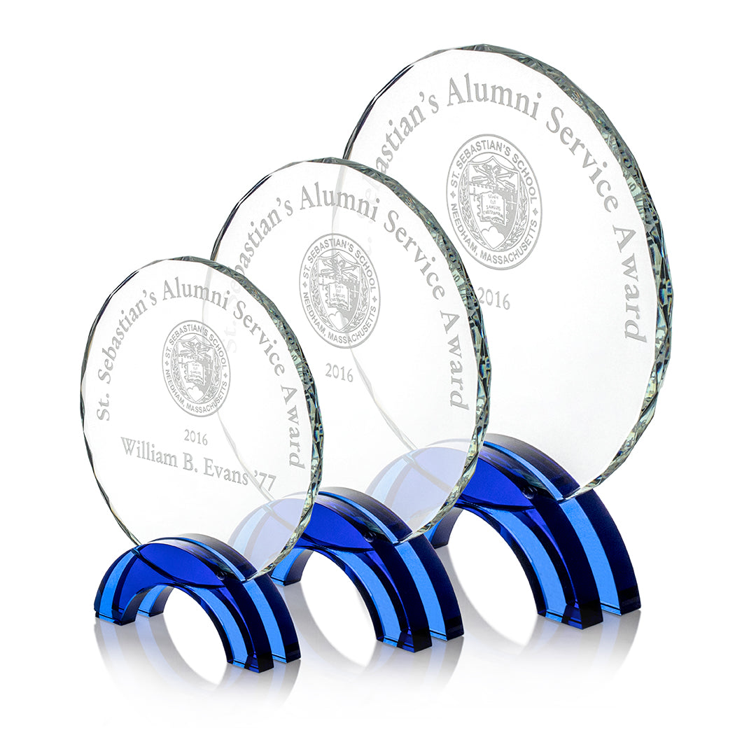 Three Crystal Newport Awards by Prize Possessions, each with blue bases, engraved for St. Sebastian’s Alumni Service Award 2016 and the school seal; the smallest award features William B. Evans '77. Ideal for employee recognition or corporate gifting.