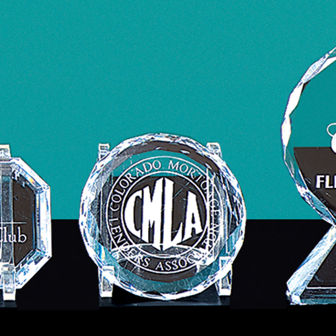Three Crystal Round Paperweights by Prize Possessions, engraved and ideal as corporate gifts or elegant desk accessories, are displayed on a turquoise background; the center piece reads COLORADO MORTGAGE LENDERS ASSOCIATION CMLA.