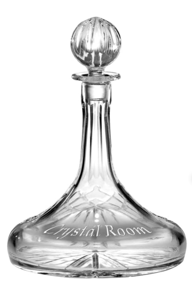 The Prize Possessions Crystal Ships Decanter features a flared clear crystal design with a round decorative stopper and "Crystal Room" etched on its base, making it an elegant addition to your bar accessories. Shown on a white background.