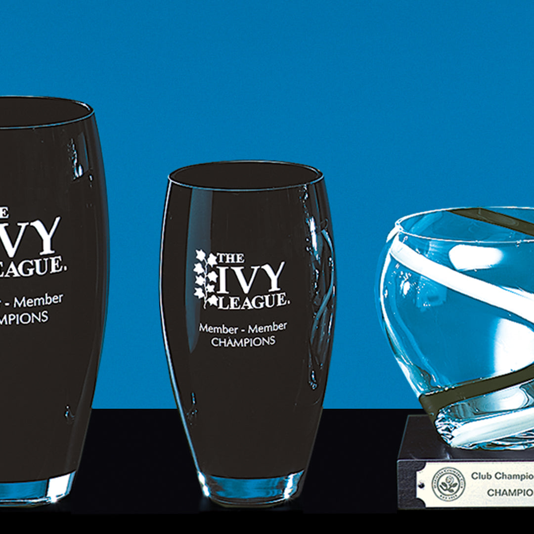 The Prize Possessions Ebony Crystal Vase stands elegantly against a blue background, creating a striking centerpiece display.