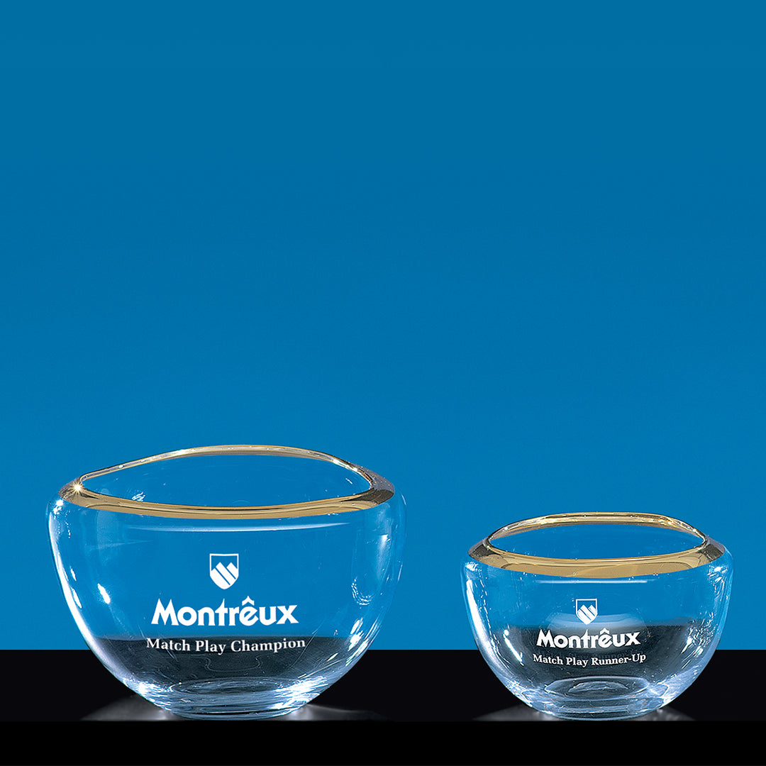 Two Prize Possessions Esher Bowls with gold rims are displayed side by side against a blue background. The larger bowl is labeled Champion and the smaller Runner-Up, creating an elegant and striking decorative centerpiece.