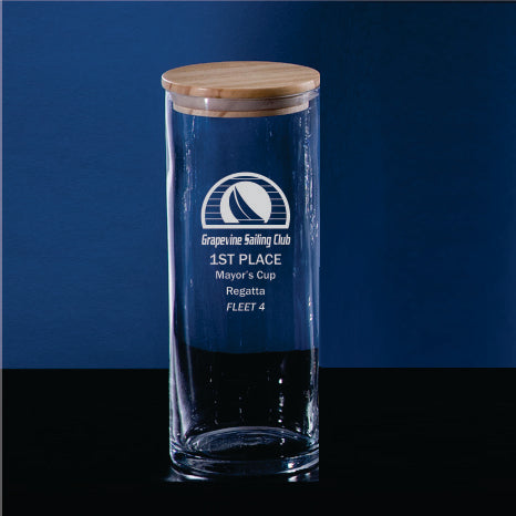 The Prize Possessions Glass Jar with Wood Cover sits on a dark background, engraved with Grapevine Sailing Club, a sailboat logo, and "1st Place Mayors Cup Regatta Fleet 4"—perfect for kitchen storage.