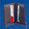 A Grey Leatherette Wallet by Prize Possessions is open on a blue background, revealing two cards—one red and white, the other blue and white—making it an ideal choice for your everyday carry.