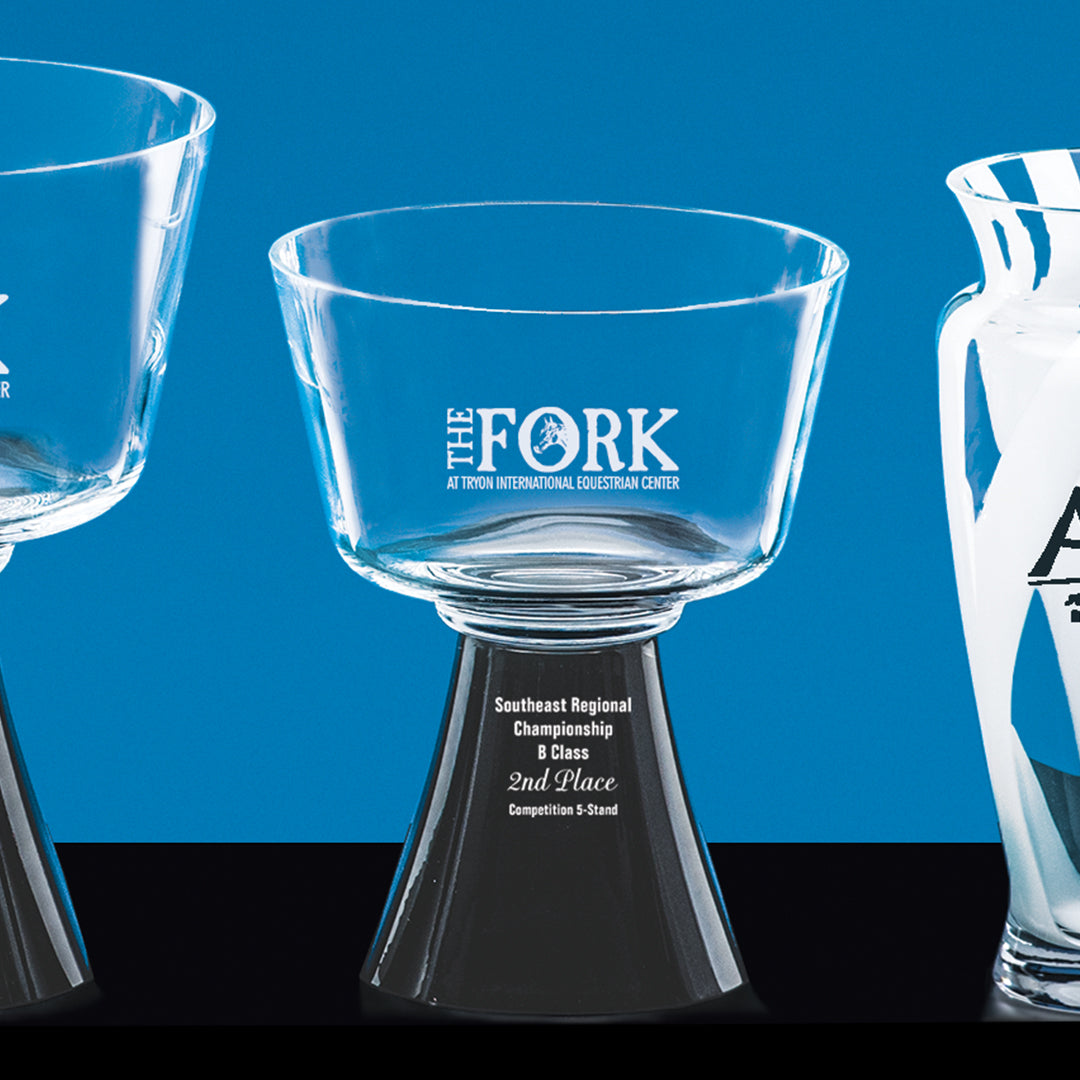 Three glass trophies stand against a blue backdrop. The center piece, Prize Possessions’ Harmony Bowl with Black Footed Base, engraved "THE FORK," has a wide bowl and is labeled 2nd Place Southeast Regional Championship.