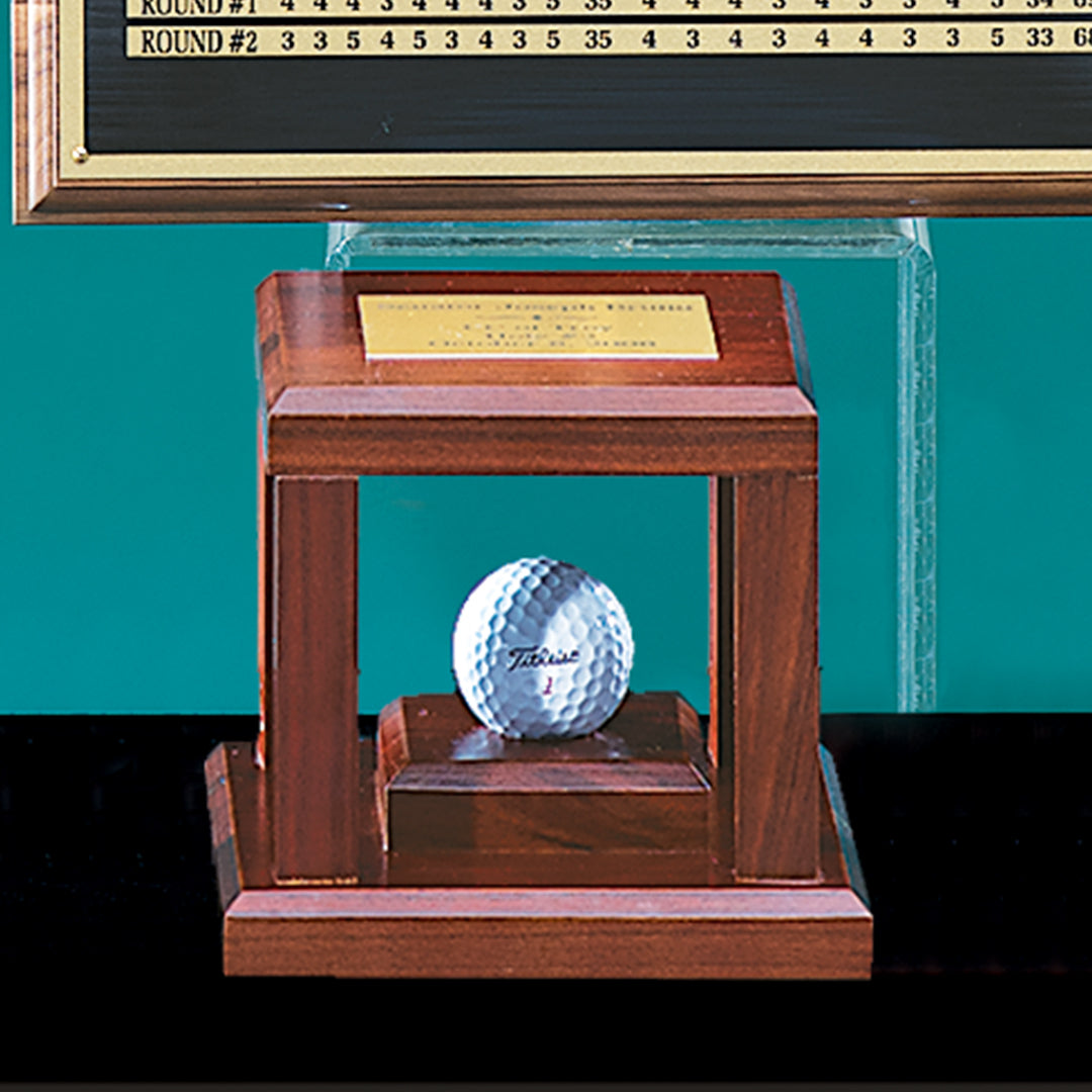 The Prize Possessions Hole In One Box is a wooden cube-shaped trophy case with a gold nameplate on top, perfect for displaying a commemorative golf ball in front of your scoreboard.