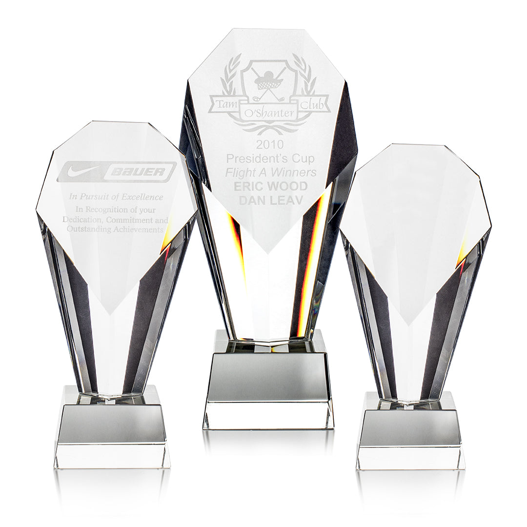 Three Prize Possessions Optic Crystal Awards are displayed, the center one engraved for the 2010 Presidents’ Cup. Their geometric design makes them ideal corporate awards or employee recognition pieces.