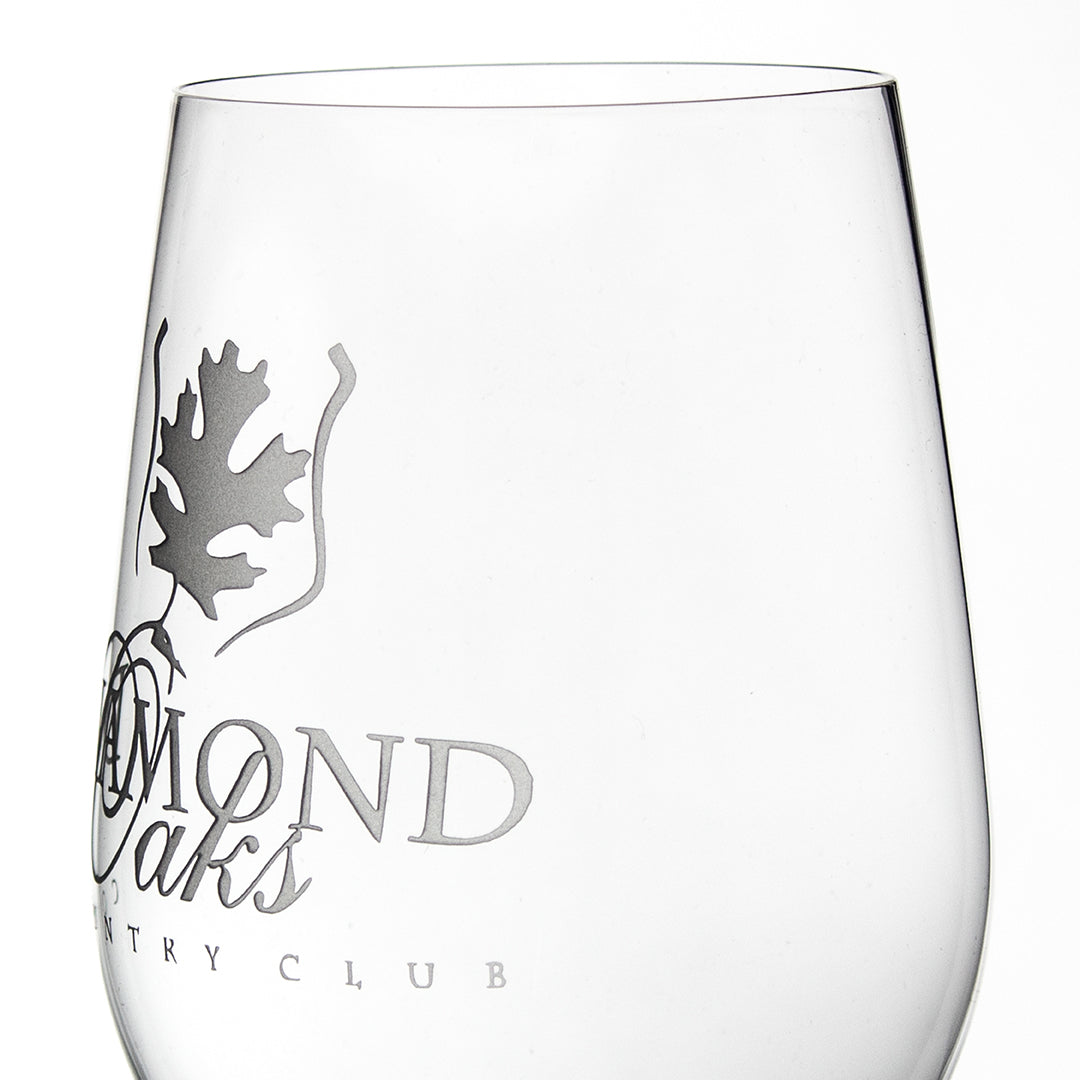 The Riedel Beer Glass by Prize Possessions features a frosted oak leaf logo and partial text "AMOND Oaks COUNTRY CLUB" on clear crystal, set against a plain white background.