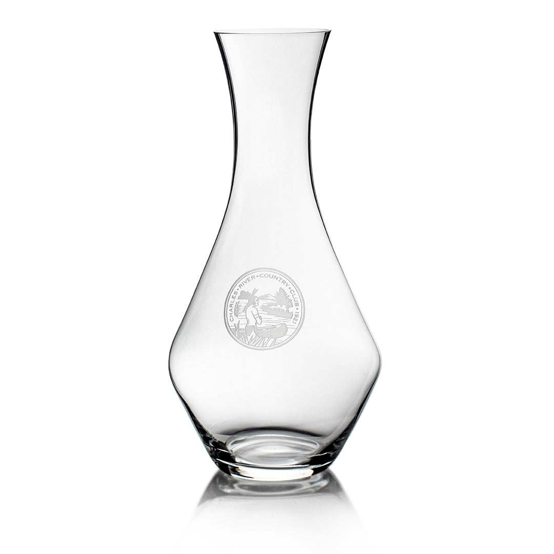 The Prize Possessions Riedel Crystal Decanter features a gently curved glass body and narrow neck, with an etched centered emblem on the front—blending classic inspiration and elegant wine aeration.