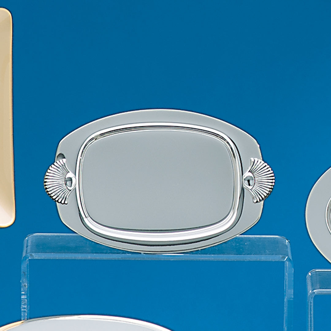The Prize Possessions Silverplate Tray with Shell handles features a rectangular center, rounded edges, and decorative shell handles on each side, making it an elegant serving accessory shown against a blue background.