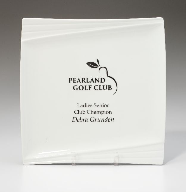 The Prize Possessions White Ceramic Pacific Plate features the Pearland Golf Club and golf ball logo, inscribed with Ladies Senior Club Champion Debra Grunden, and is displayed upright on a clear stand.