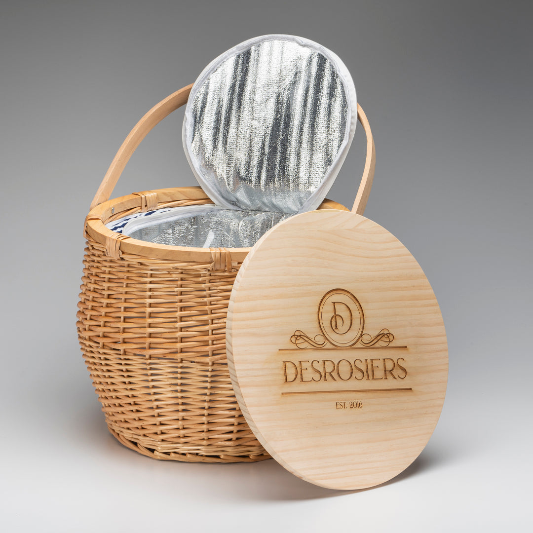 A Prize Possessions Willow Picnic Basket Cooler with an open insulated lid and wooden cover engraved "DESROSIERS EST. 2016" sits against a plain gray background.