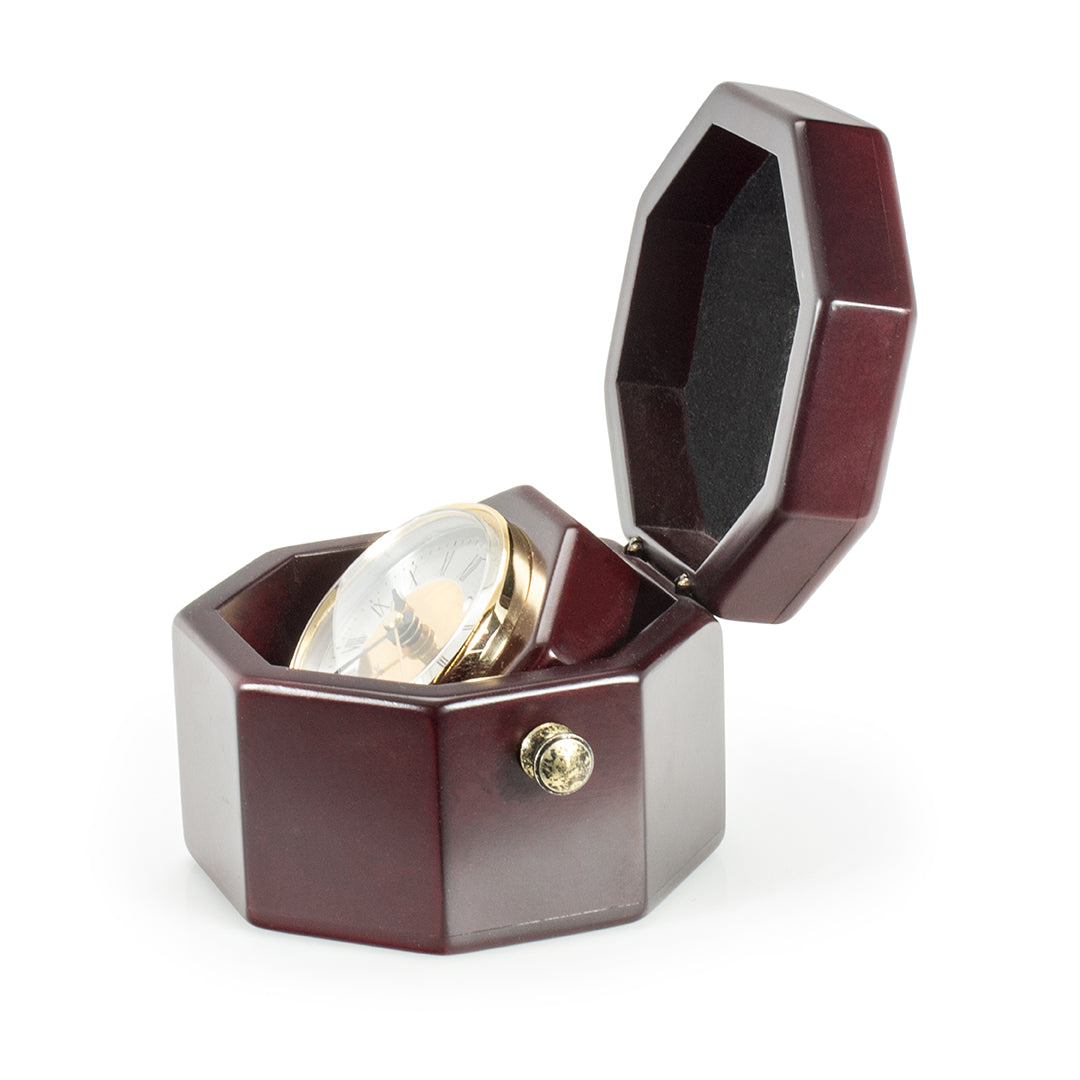 The Prize Possessions Wood Case Clock is displayed in an open, dark wood, octagonal box with a hinged lid lined in black fabric, reminiscent of a classic brass compass presentation.