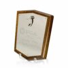 The Prize Possessions Wood Shield Plaque features an engraved inscription and a small metallic emblem at the top, set on a clear stand against a white background.